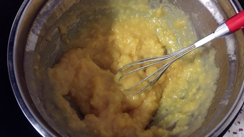 奶黄冰皮月饼,5分钟后，打开锅盖用手动打蛋器搅拌奶黄糊，不断地搅拌，让周边的奶黄糊混合均匀。
