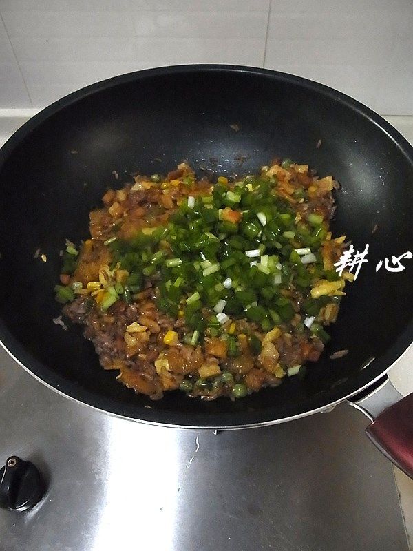 红米炒饭,放入葱粒，炒匀。