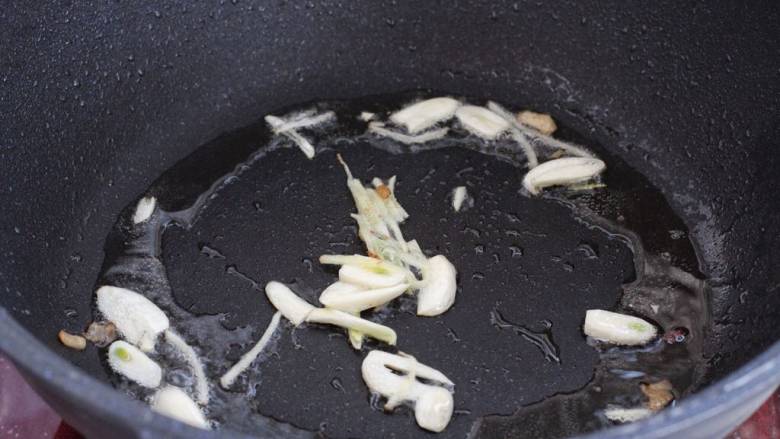 芹菜木耳炒肉丝,就锅中底油放入蒜片和姜丝，小火炒出香味。