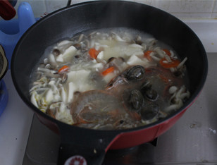 菌菇豆腐海鲜煲,加入鲜虾和花蛤，煮到蛤蜊开口，鲜虾熟透，撒香菜出锅即可。