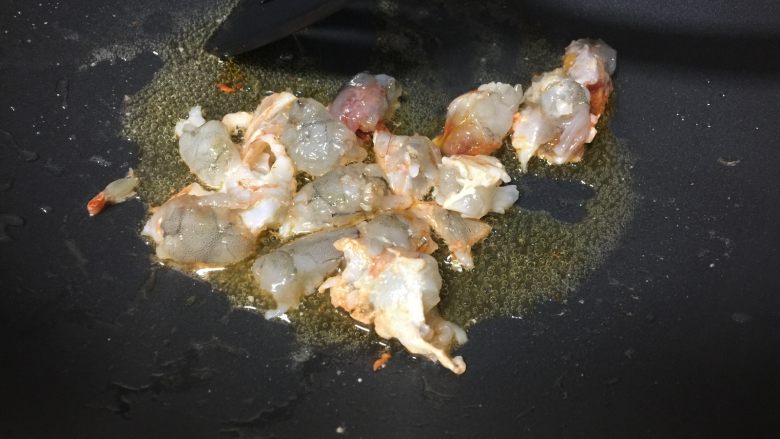 黄金蛋包饭,锅内加适量油，烧至六成热时放入虾块儿炒至变色。