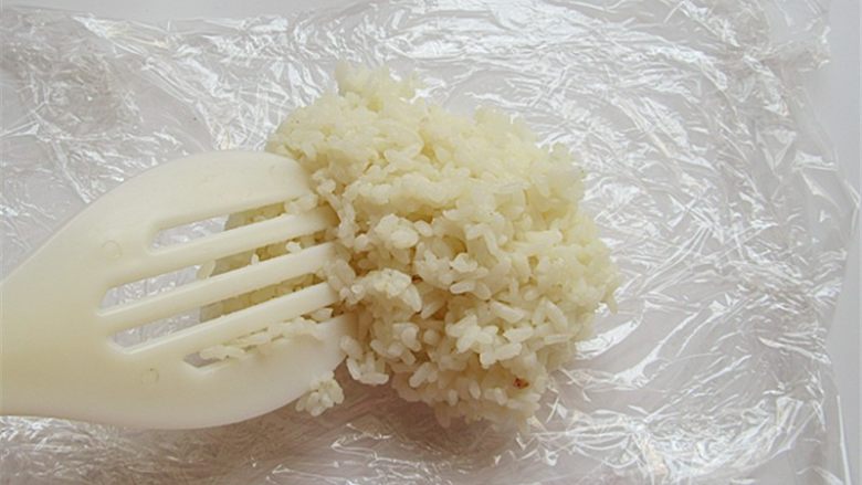 小熊奶酪包饭趣味便当,温热米饭放在双层保鲜膜上摊平