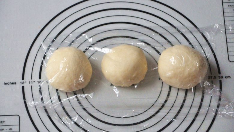 淡奶油椰蓉面包卷,将面团取出，按揉排气后面团均分成三团，盖上保鲜膜松弛15分钟。