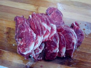 麻辣水煮牛肉,将牛里脊肉稍微解冻，切2厘米左右的片，注意切的方向和厚度。切好后用刀背拍一下，让纤维松散一些。