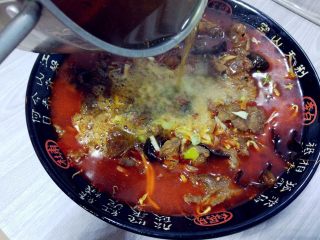 麻辣水煮牛肉,表面撒少许葱花，干辣椒，将烧热的辣椒油和麻油浇在上面即可。