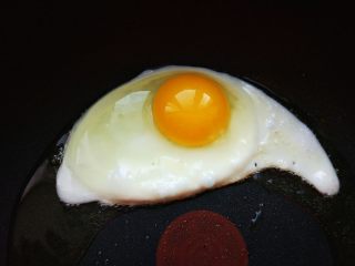 韩式酸辣鱿鱼盖饭,热锅热油，将鸡蛋打入平底不粘锅，煎至七八成熟，就是底部凝固，边缘有焦痕，蛋黄表面薄薄一层稍有流动的样子