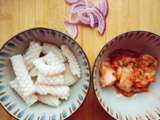 韩式酸辣鱿鱼盖饭,在七八十度的水中快速焯一下，沥净水份备用，切洋葱，准备辣白菜