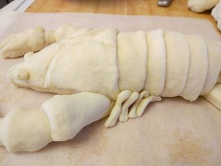 龙虾面包,搓细条，一端剪开，粘少许蛋液摆在适当的位置，充当小腿