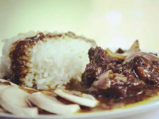 日式咖喱牛肉饭,口蘑开水过一分钟后切片排放到盘内，添上米饭和做好的咖喱牛肉