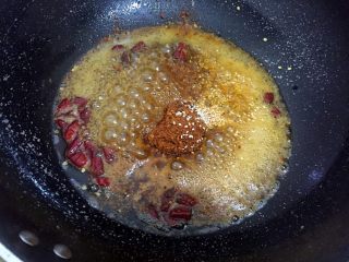 麻辣牛肉干,锅中放入热油，烧热后换低温小火，放入辣椒面、红辣椒干节、白芝麻，炒制2分钟