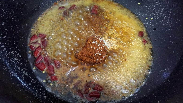 麻辣牛肉干,锅中放入热油，烧热后换低温小火，放入辣椒面、红辣椒干节、白芝麻，炒制2分钟