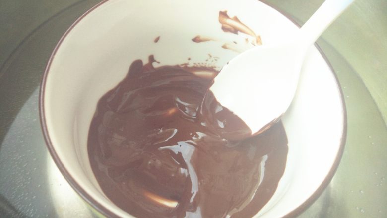 雪国的树——椰蓉巧克力杯蛋糕,烤蛋糕的同时，准备巧克力树插件。黑巧克力隔水融化（小火，不要有水滴入巧克力中），装入裱花袋中。或放入微波炉中加热30秒左右。