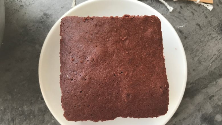红丝绒巧克力淋面蛋糕,放一片蛋糕片在容器上。
