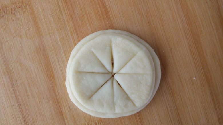 原味麦香小面包,制作太阳：另取剩下的面团，擀成薄片，在每篇中间刷油后，摞在一起，如图切开，边缘不要切断。