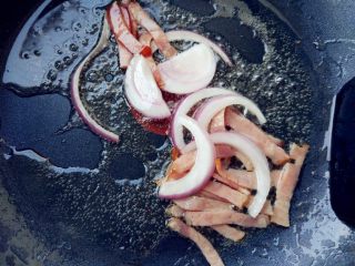 干煸菜花,热锅热油，倒入比平时炒菜稍多的油，下洋葱和培根炒几下