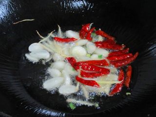 丝瓜炒虾仁,另起一锅，锅预热注入油，放进姜丝、蒜头、红干椒煸炒出香味