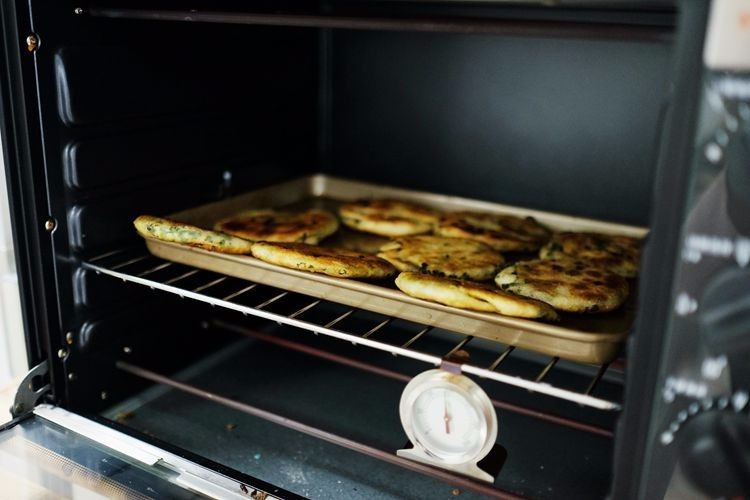上海葱油饼,将煎好的饼放入烤盘中，然后进烤箱烘烤至表面变干（2面都要）这样，香喷喷的葱油饼就做完啦。