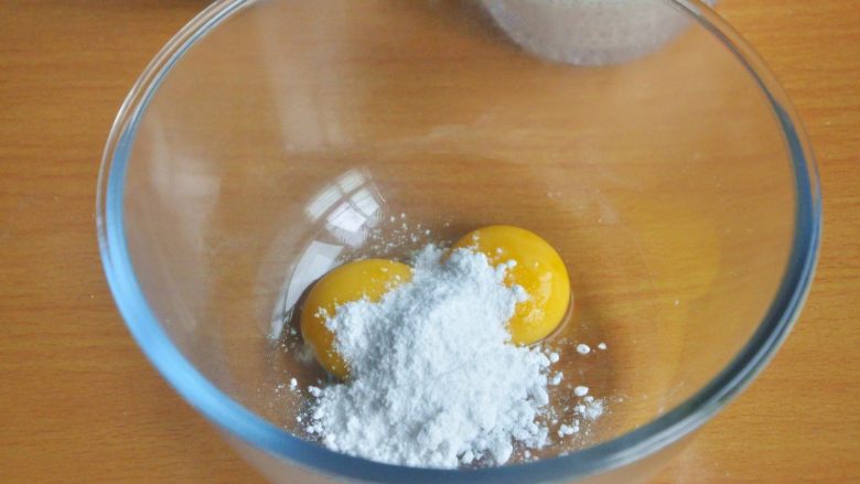 原味松饼（无泡打粉版）,在装有蛋黄的打蛋盆中倒入糖粉。