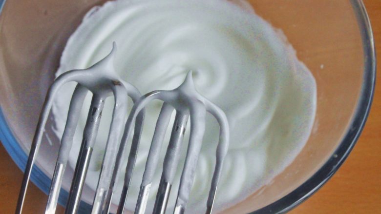 原味松饼（无泡打粉版）,在蛋清中分三次加入糖粉，低速打发，直至蛋白越来越细腻，提起一个小弯勾。