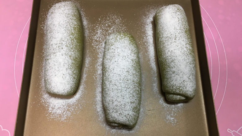 抹茶凤梨全麦面包,30分钟左右面包发酵完成，取出后在面包表面筛一层干粉。