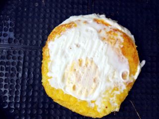 创意南瓜米饭煎蛋饼,翻面，上面打一个鸡蛋，电饼铛上下火同时加热至八成熟即可
