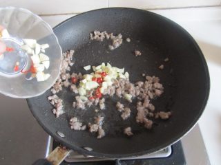 雪菜肉末烧豆腐,肉末煸炒变色后加入蒜末和红辣椒翻炒；