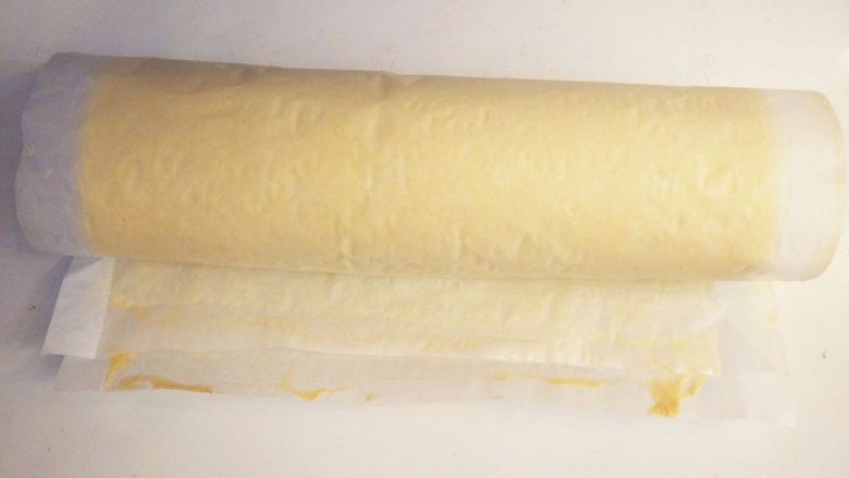 黄桃奶油蛋糕卷,将蛋糕体从有黄桃块的一端卷到另一边，接口朝下，入冰箱冷藏片刻