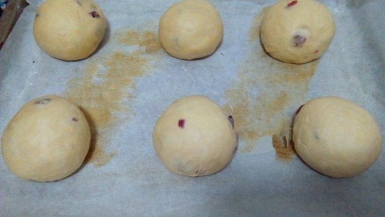 红糖蔓越莓软欧,松驰好的面团再次滚圆（蔓越莓尽量包在里面）放在铺有油纸的烤盘；