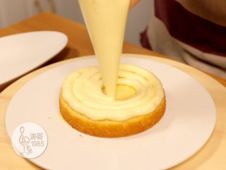黄桃裙边蛋糕,放上一片蛋糕之后，在上面挤上瑞士奶油霜，外圈要高一些，内圈要低一些