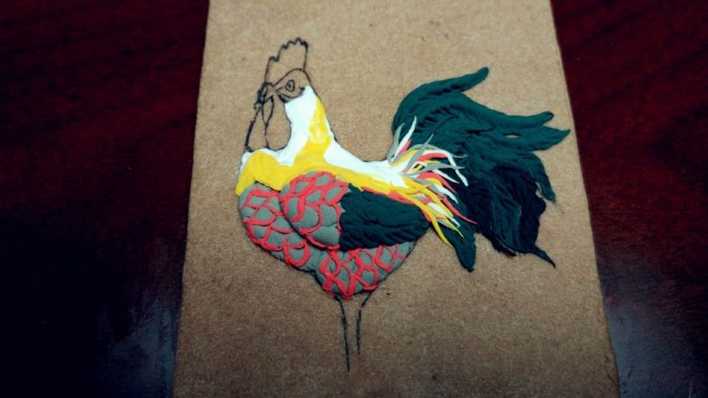 鸡年大吉翻糖饼干,按照图案，填满颈部和背部，留出鸡冠和鸡嗉子的位置，搓杂色细条，填充尾羽和背部的空隙