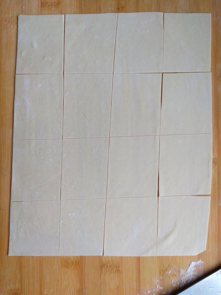 家常三鲜小馄饨,取一块儿面团，擀成薄片，先纵向切成宽度相当的片，再横向切，这样就切出方形的面片。