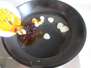 青椒酿肉,热锅凉油， 放入蒜瓣和豆豉酱进去煸炒；
