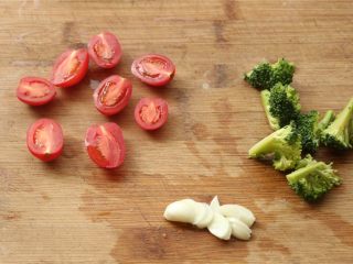 番茄罗勒意面,圣女果选择小一点的，切两半，西兰花拆分成小朵，蒜切片。