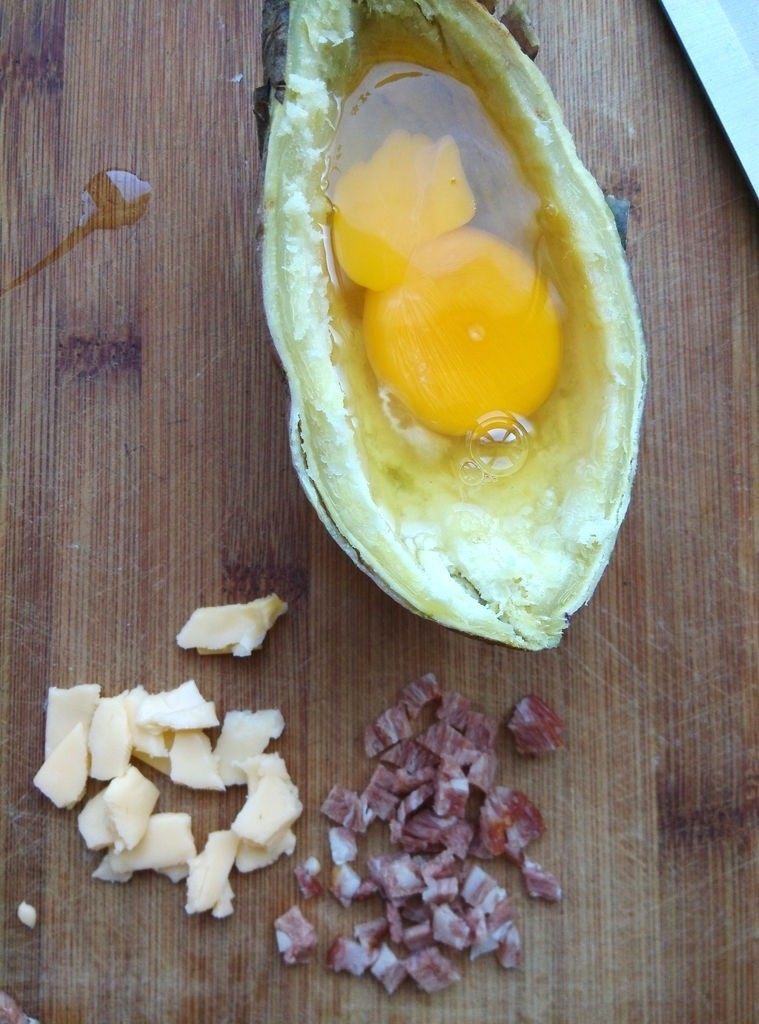 红薯奶酪焗蛋,将一个<a style='color:red;display:inline-block;' href='/shicai/ 9'>鸡蛋</a>打进坑里，用牙签扎破蛋黄表面的膜，让蛋黄流出来。同时将培根和少许切达奶酪切小丁。