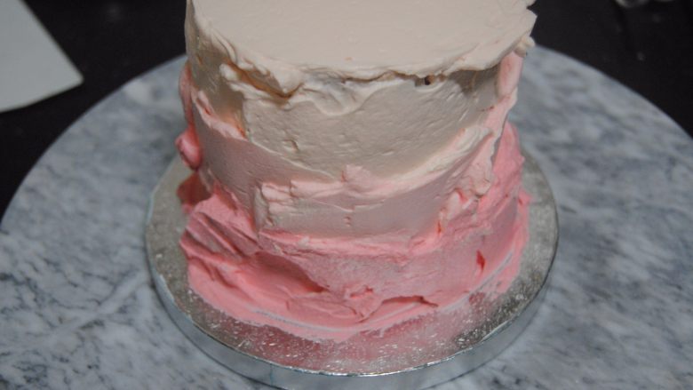 巧克力淋面蛋糕,剩余的淡奶油加入细砂糖和一滴红色素打发，取1/3抹在最上面层，剩余的再加入一点点红色素混匀，取出抹在蛋糕边上