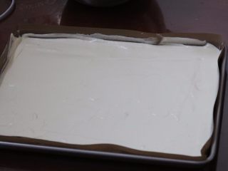 马斯卡彭芝士草莓卷,7.把蛋糕糊倒入铺有油布的烤盘内 振动气泡 表面可以用刮板刮平
