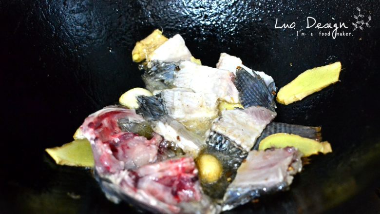 香煎罗非鱼,然后把鱼身骨和鱼头鱼尾放进去翻炒至熟。