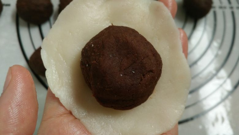 花朵冰皮月饼,10.把分割好的饼皮擀成中间后边缘薄的圆形即可，包入25克的红豆馅
