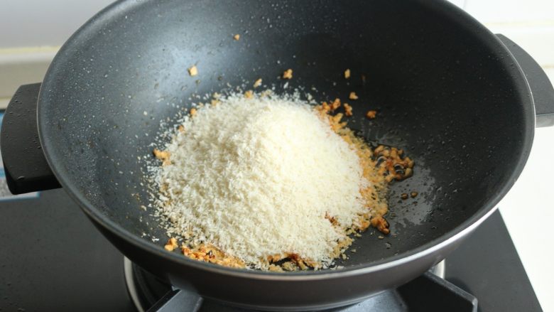 避风塘炒虾,倒入面包糠，要快速搅拌，面包糠会迅速吸干所有的油，变得焦脆。