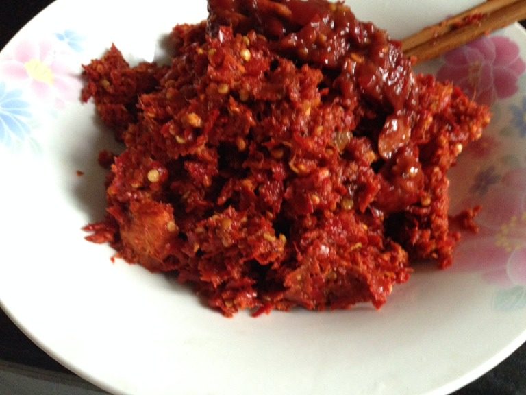 贵州辣子鸡,首先准备这样的辣椒，贵州的特 色辣椒，可在网上买，也可自己制作。适量的干辣椒用热水泡半个小时，加大蒜、姜一起捣碎。