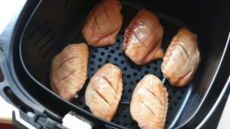 无油照烧烤鸡翅,腌好的鸡翅铺在炸锅的炸篮里。