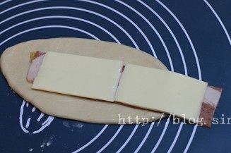 培根奶酪,翻面后，分别铺上培根及奶酪片，轻轻卷成圆柱体