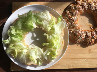 燕麦辫子花环汉堡面包,将面包从中间横着切开，中间放入自己喜欢的蔬菜。