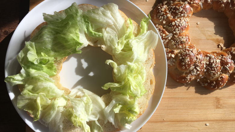 燕麦辫子花环汉堡面包,将面包从中间横着切开，中间放入自己喜欢的蔬菜。