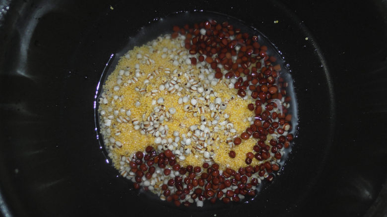 养生粥合集,将泡好的红豆和薏米、小米一起倒入电饭锅内