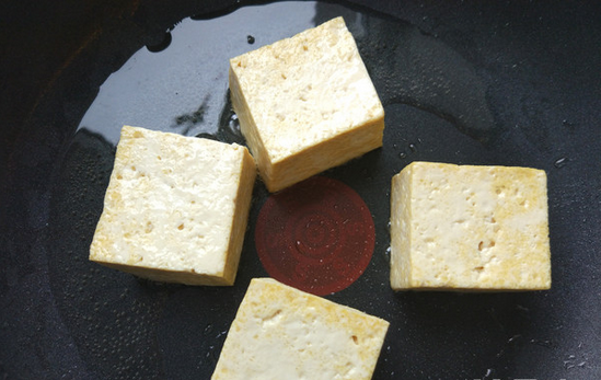扇贝蝴蝶虾蒸豆腐（含豆腐做法）,将豆腐切方块，在热锅热油中煎一下定型