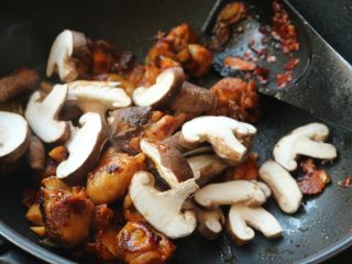 辣子鸡,下入香菇继续炒2分钟。