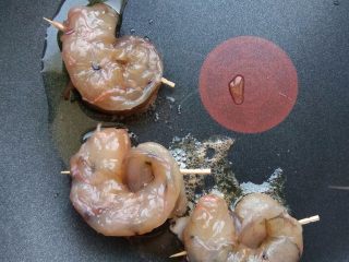 儿童蔬菜汤饭,将腌好的虾仁背部开一个小洞，将尾部插入，再用牙签固定一下。热锅热油，将虾仁做的小蜗牛煎至两面熟透。