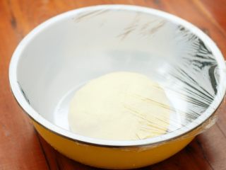 香葱肉松面包,将揉好的面团放到盆里，盖上保鲜膜放到温暖处发酵。