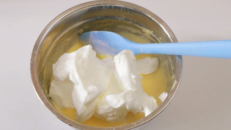 淡奶油戚风蛋糕（后蛋法）,取1/3蛋白霜加入蛋黄糊的盆中，翻拌均匀
